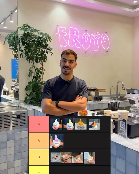 Ranking the toppings in front of the pink neon Froyo sign